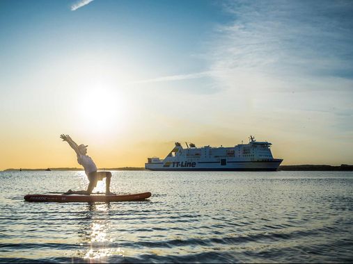 Mann macht Yoga auf dem Wasser auf einem SUP-Board 